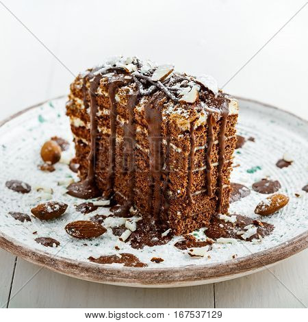 Beautiful dessert on a table. Delicious chocolate Spartak cake served on a beautiful rustic plate. International haute cuisine dessert.