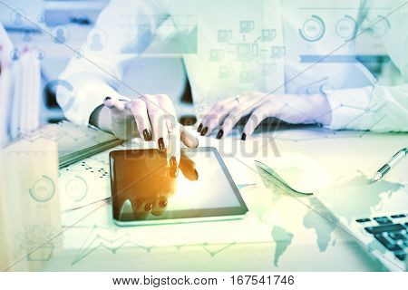 Close up of female hands at office desk using tablet with business charts. Young accountant at workplace. Accounting concept