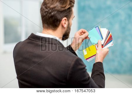 Elegant architect or designer choosing color for painting walls or apartment decotation from the color sample