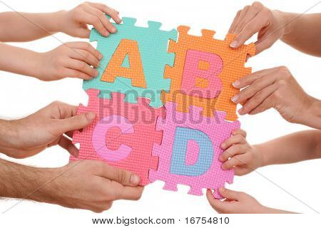 mãos segurando o quebra-cabeça com letras ABCD isoladas no branco