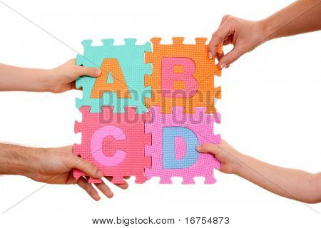 mãos segurando o quebra-cabeça com letras ABCD isoladas no branco