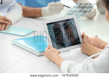 Young doctor exploring lung roentgenogram in clinic
