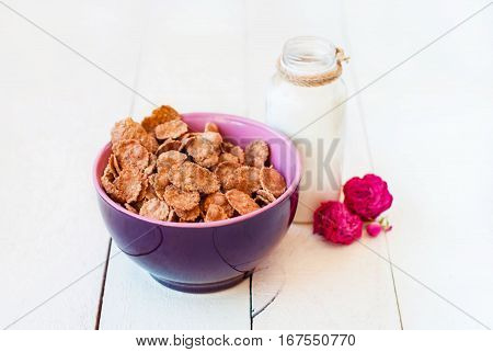 Romantic breakfast with cereal and milk on a light background with dried roses