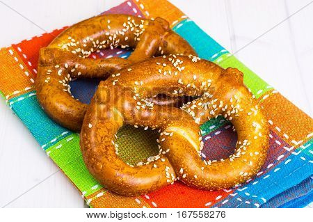 Bavarian pretzels with sesame seeds on white boards. Studio Photo