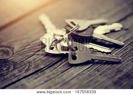 The bunch of keys lies on a wooden table.