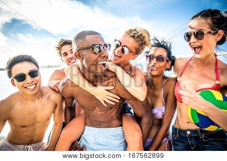 Group of friends playing beach volley - Multi-ethic group of people having fun on the beach
