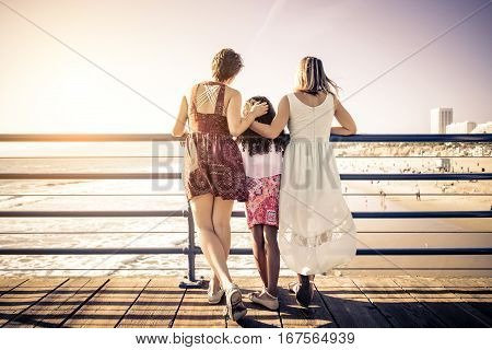 Lesbians mothers with adopted child - Happy homosexual family playing with her daughter