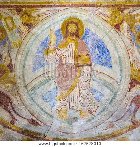 Medieval mural of Christ pantocrator sitting on the rainbow. Symbols of the four evangelist Lackalanga Sweden - May 6 2015
