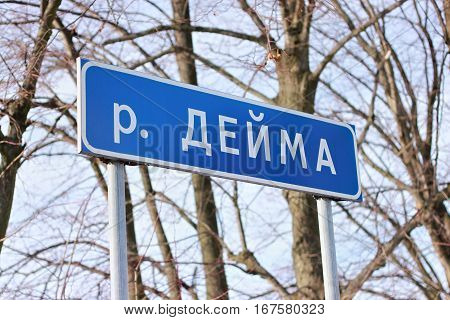 A typical russian road sign with the designation of proximity to the river. The inscription in russian text translated as river Deima.