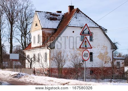 Old german building near road signs in Polessk (Labiau). Kaliningrad region Russia.