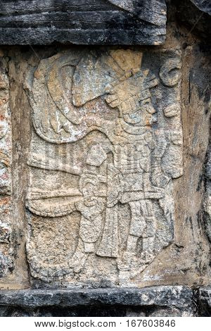 Ancient Mayan mural depicting a warrior holding a human head on the Platform of the Skulls a.k.a. Tzompantli in Chichen Itza Yucatan Mexico