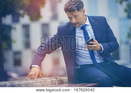 Portrait of stylish businessman using digital tablet on retaining wall