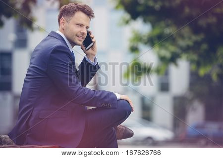 Handsome businessman wearing suit talking on mobile phone