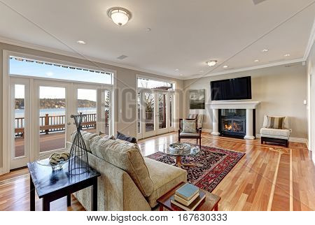 Luxury Spacious Family Room With Wall Of Glass Doors Facing The Lake.