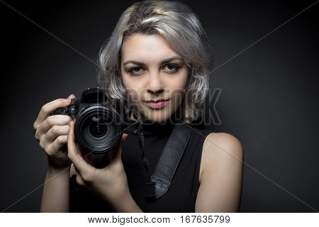 Female professional or amateur photographer holding a dslr camera. This photographic gear is used by both self employed artists and journalists or for tourism and hobbies.