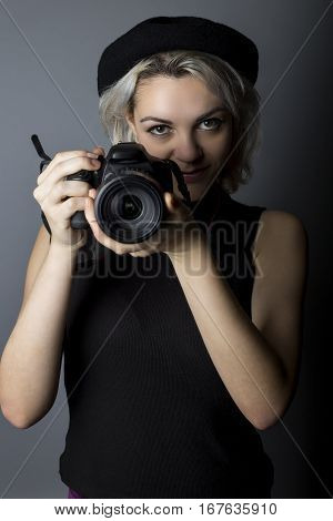 Female professional or amateur photographer holding a dslr camera. This photographic gear is used by both self employed artists and journalists or for tourism and hobbies.