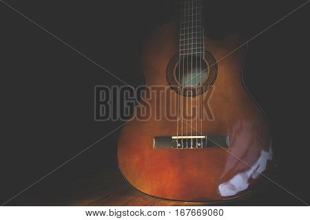 Acoustic guitar against on the wooden background.