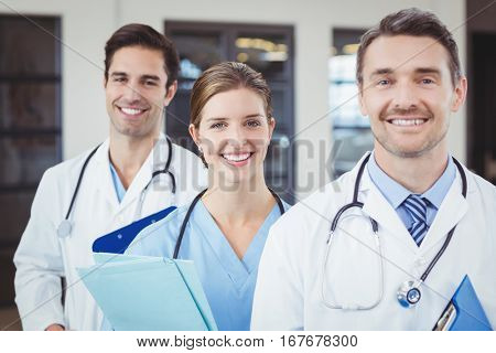 Portrait of cheerful docors standing in row at hospital