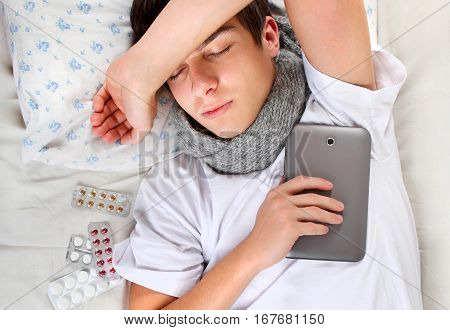 Sick Young Man sleep with Tablet Computer on the Bed