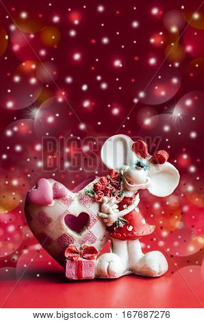 statuette of a little mouse with a bouquet of flowers on a red background