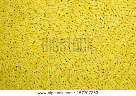 a scattering of yellow medical tablets, capsules