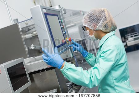 factory worker is checking control panel in pharmaciutical factory