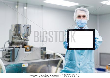 Scientist Near Steel Machine Hold Empty Tablet, Focus On Tablet, Blured Back