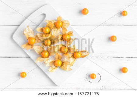 physalis on cuttinng board on wooden white background