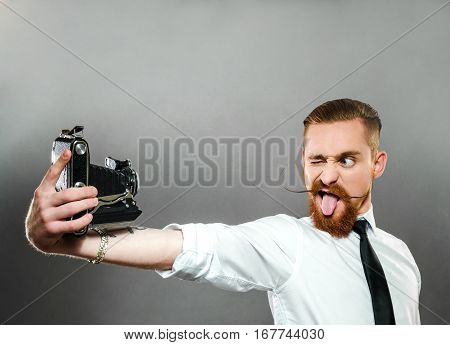 stylish the guy with the long whiskers shows language and makes selfie