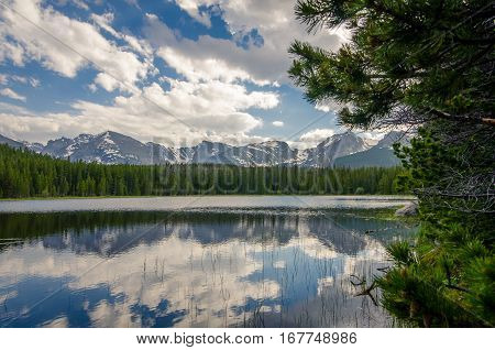 Mountainside lake. A lake surrounded by a forest and mountains.