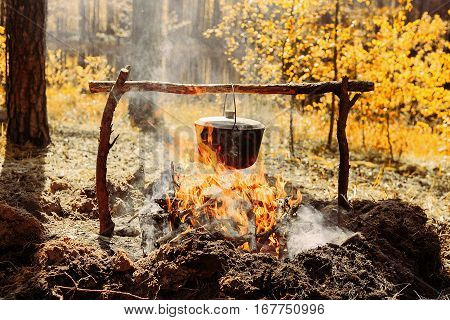 The fire near the camp. Cooking food on a fire. Journey into the wild concept.