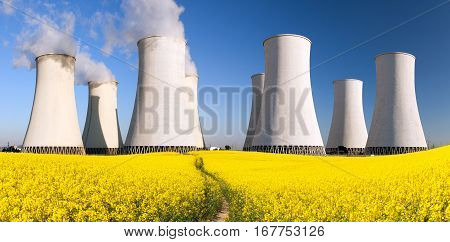 Panoramic view of Nuclear power plant Jaslovske cooling tower Bohunice with golden flowering field of rapeseed - Slovakia - two possibility for production of electric energy