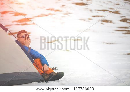 A Man Sits In A Tent In The Winter.