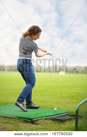 Woman with cammock plays golf on green golf course at summer