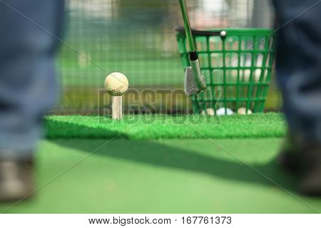 Man hitting ball for golf during training, focus on ball, shallow dof, noface