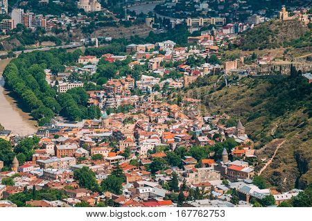 Tbilisi Georgia. Aerial View Of Hillside With Famous Landmarks: Tabor Monastery Of The Transformation, Narikala Fortress And Surb Gevorg Church Among Residential Area With Red And White Roofs.