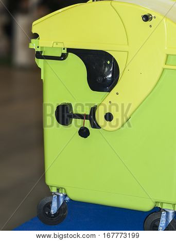 Green plastic tank for garbage collection is on wheels