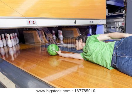 Young Man Sliding Down A Bowling Alley