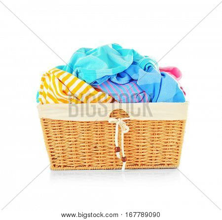 Clothes in wicker basket on white background