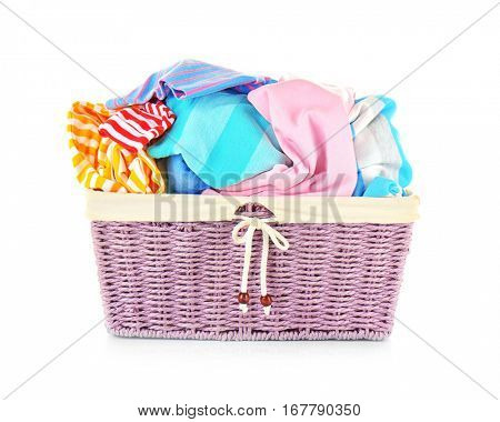 Clothes in wicker basket on white background