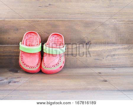 Top view of colorful Children's rubber sandals on wooden background