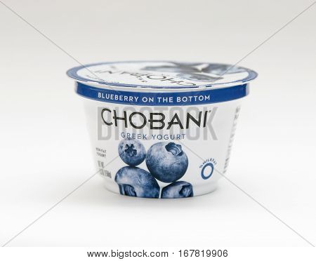 New York January 23 2017: A container of blueberry Chobani greek yogurt stands against white background.