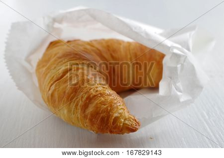 frest tasty croissant in a paper bag
