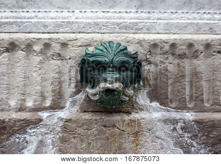 demon head. A fragment of a medieval fountain to drink. Lyon. France.