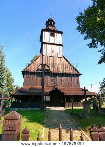 Photo of a small wooden church under a blue sky