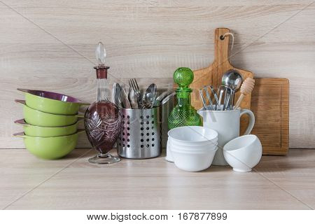 Crockery tableware utensils and other different stuff on wooden table-top. Kitchen still life as background for design. Image with copy space.