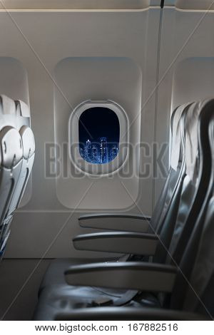 View Of Modern City Skyline At Night In An Airplane Window