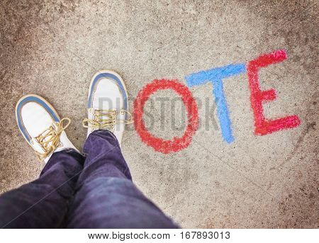 a pair of shoes in the form of the letter V for vote on a sidewalk toned with a retro vintage instagram filter