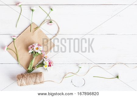 Workspace with small bouquets of daisy flowers paper bags. Creation. Top view flat lay