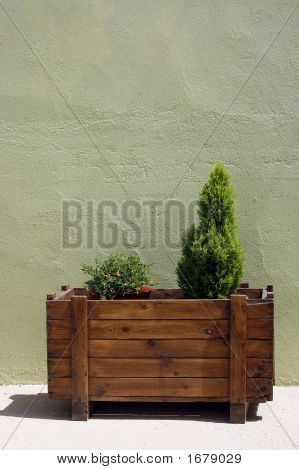 Houten bloempot en groene muur